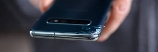 Man hold in hand modern smartphone with cracked corner close-up