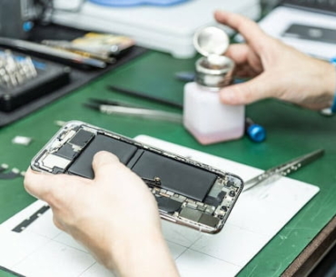 unrecognizable technician repairing smart phone in his repair shop