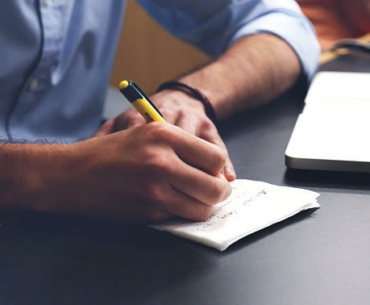man writing laptop studying
